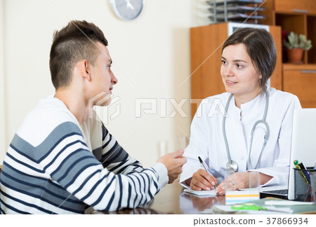 Female doctor questioning teen patient at office Female doctor questioning teen patient at office 37866934