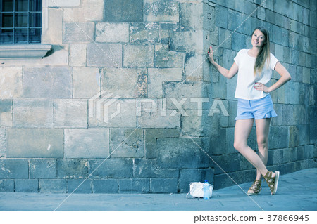 Young woman on old stone wall background Young woman on old stone wall background 37866945