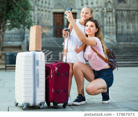 Woman with little daughter traveling together, taking selfie 37867073