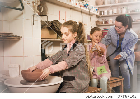 Students gently work the potter's wheel Students gently work the potter's wheel 37867102