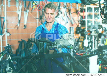 man in uniform repairing bicycle 37867246