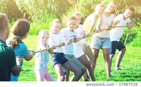 Glad kids with moms and dads playing tug of war Glad kids with moms and dads playing tug of war 37867538