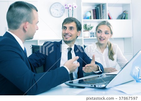 Three glad coworkers having a conversation Three glad coworkers having a conversation 37867597