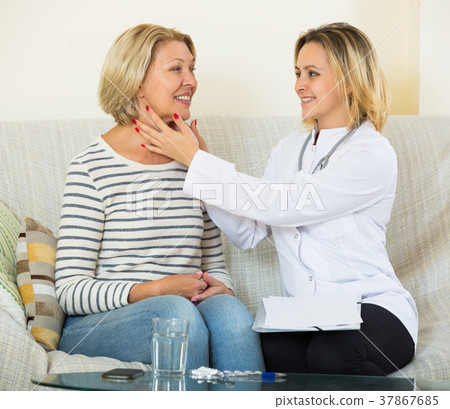Female doctore doing check up of senior patient with quinsy 37867685