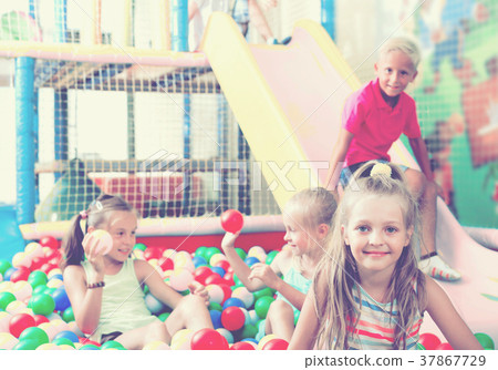 Girl playing with multicolored plastic balls Girl playing with multicolored plastic balls 37867729