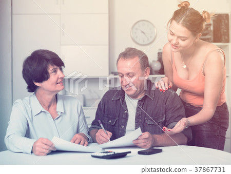 Adult couple is singing contract with their daughter 37867731