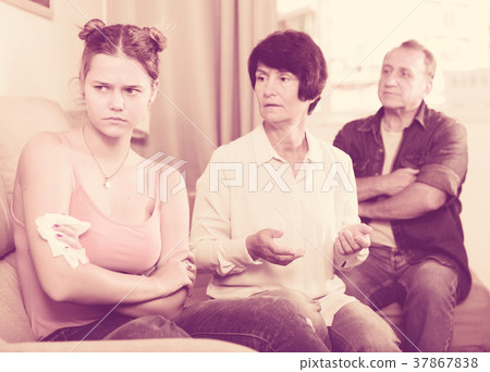 Parents are comforting the upset adult daughter on sofa Parents are comforting the upset adult daughter on sofa 37867838