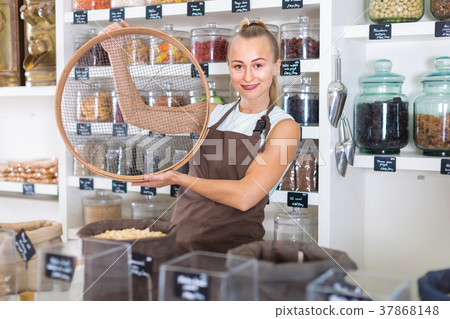 Female seller is working with ring for grind nuts 37868148