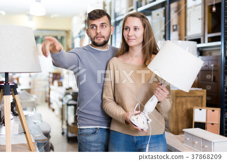 Girl with boyfriend in search of table lamp 37868209