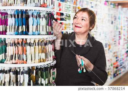 Mature woman is buying colorful mouline threads 37868214