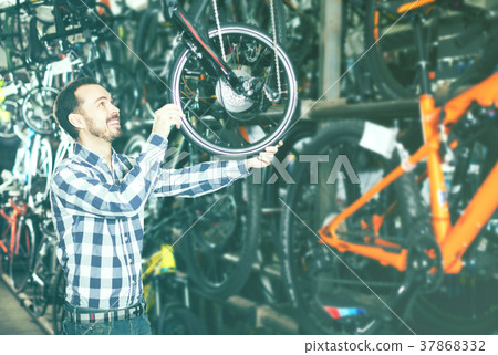 Man considers bicycle frame in store 37868332