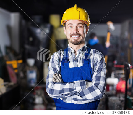 Young smiling worker displaying his workplace Young smiling worker displaying his workplace 37868428