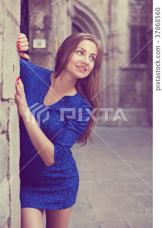 Young woman is posing in blue dress near old wall Young woman is posing in blue dress near old wall 37868560