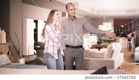 Glad couple choosing furniture for apartment 37868788