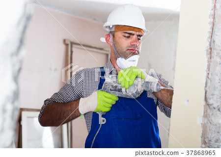 Portrait of professional repairer man standing with drill indoors 37868965
