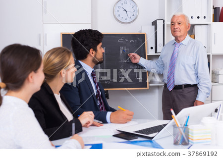Mature boss is introducing subordinates in project on the meeting Mature boss is introducing subordinates in project on the meeting 37869192