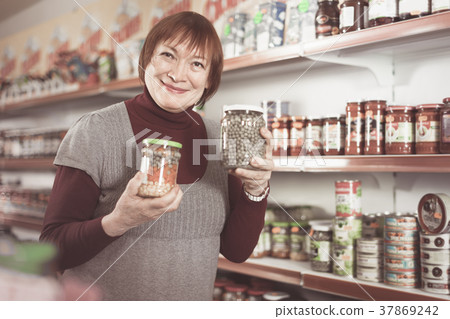 woman buyer buying canned jar of peas woman buyer buying canned jar of peas 37869242