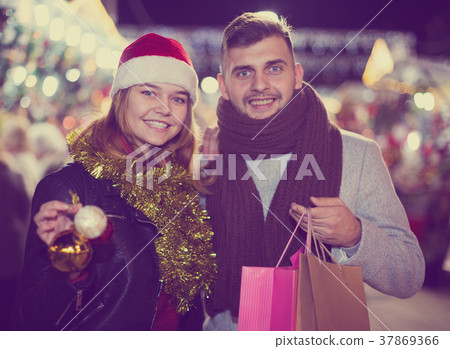 Couple in Christmas hat with purchases at Christmas Fair Couple in Christmas hat with purchases at Christmas Fair 37869366