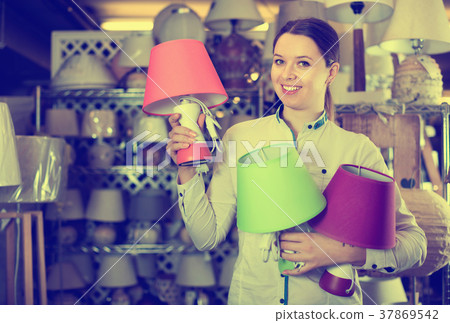 Woman is demonstraiting new lamp for her home in the store. 37869542