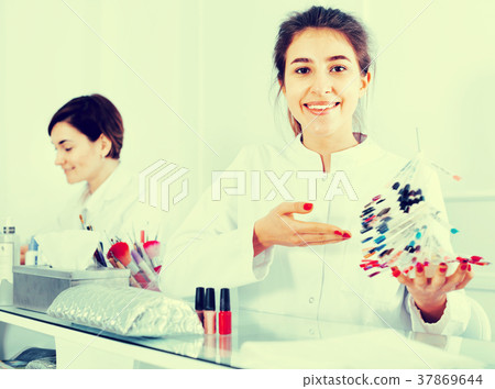 Female manicurist showing lacquer color schemes Female manicurist showing lacquer color schemes 37869644