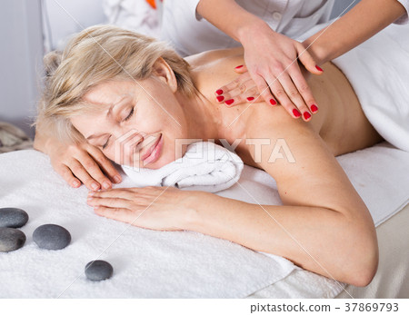 Mature woman having massage Mature woman having massage 37869793