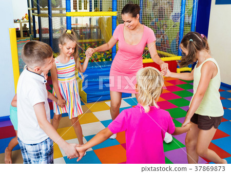 Kids holding each others hands and dancing with teacher 37869873