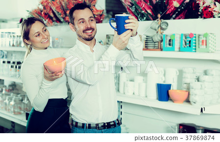 Couple choosing new crockery in dinnerware store Couple choosing new crockery in dinnerware store 37869874