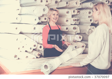 Woman seller displaying diverse fabrics 37870097