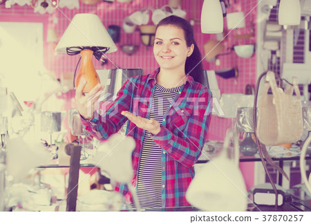 Female customer decided to buy a table lamp 37870257