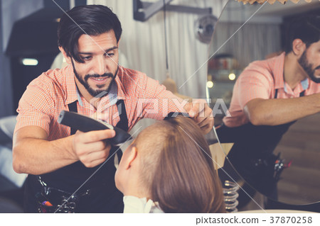 hairdresser working with hair clipper 37870258