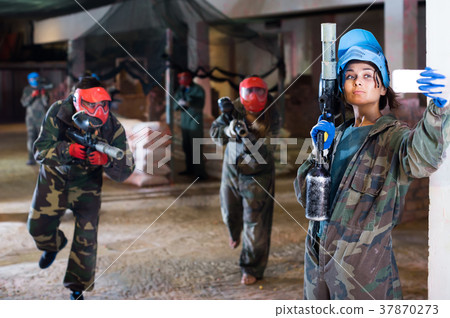 woman is making selfie in paintball battle. woman is making selfie in paintball battle. 37870273