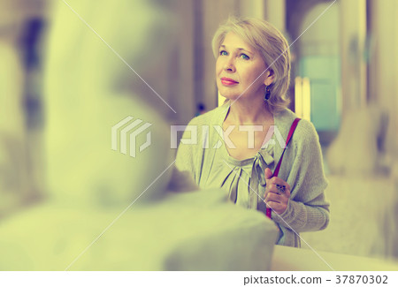 Adult female looking at artwork sculpture in the museum indoors 37870302