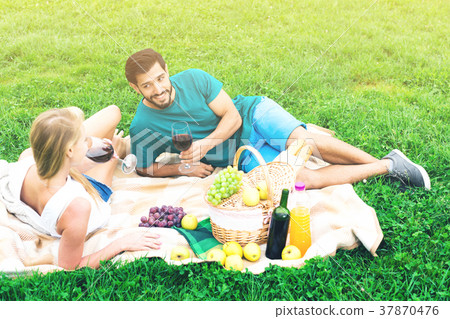 Smiling couple is lying with wineglasses and talking 37870476