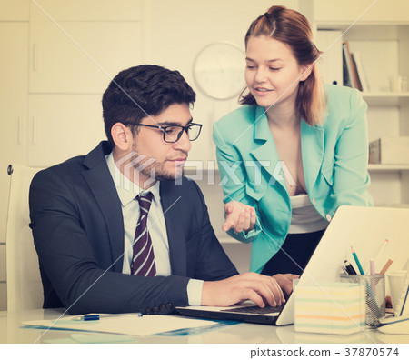 Businessman and businesswoman working together Businessman and businesswoman working together 37870574