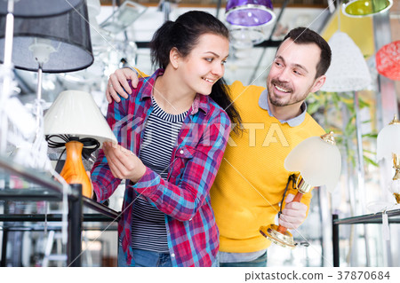 Woman and man in shop of home appliances are choosing night lamp Woman and man in shop of home appliances are choosing night lamp 37870684