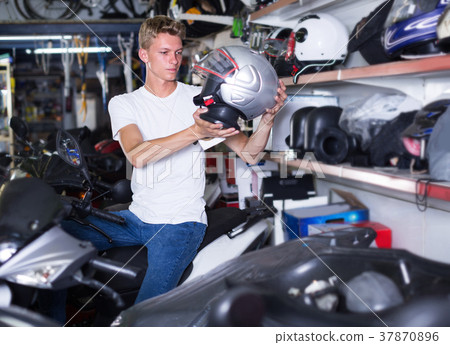 Man is choosing helmet for motorbike Man is choosing helmet for motorbike 37870896