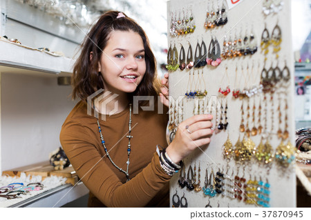 Young girl seller offering colored earrings Young girl seller offering colored earrings 37870945