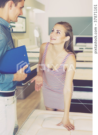 Ordinary seller demonstrating to woman mattress 37871101