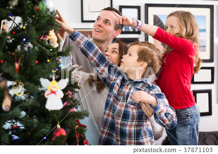 Charming parents with children preparing for Christmas Charming parents with children preparing for Christmas 37871103