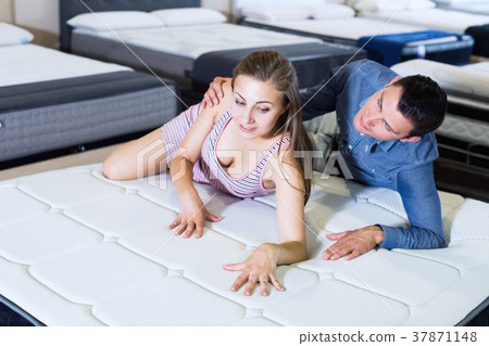 Couple choosing mattress Couple choosing mattress 37871148