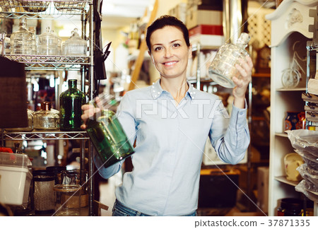 female chooses glass decorative bottles 37871335