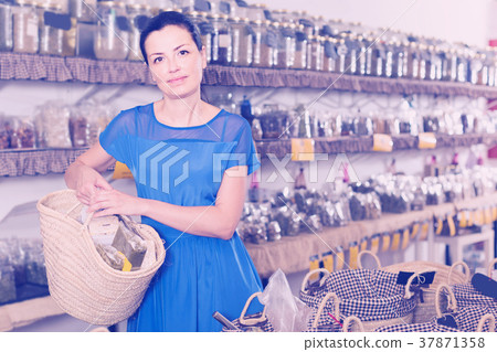 adult woman showing shopping bag and smiling in organic shop 37871358