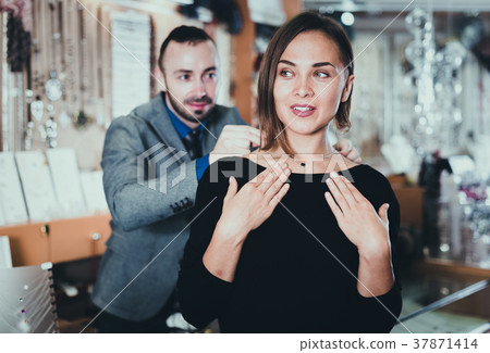 Woman trying stylish chainlet with pendants 37871414
