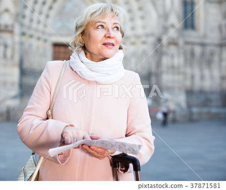 mature female tourist holding map mature female tourist holding map 37871581