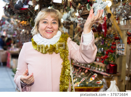 female on Christmas Fair looking on decoration 37871684