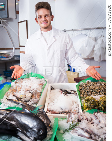Seller posing near cooled fish 37871920