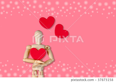 Wooden man figure holding red heart balloon. Wooden man figure holding red heart balloon. 37873158