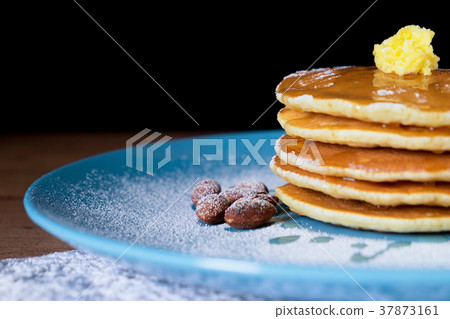 Pancakes with honey and almonds on blue plate food 37873161