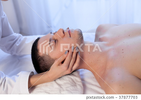 doctor cosmetologist doing facial massage men spa 37877703