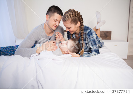 mom dad and son in the morning lying on the bed at mom dad and son in the morning lying on the bed at 37877754